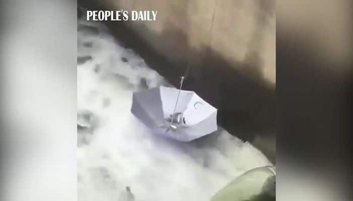 Çində kişi balıq tutmaq üçün çətirdən istifadə etdi